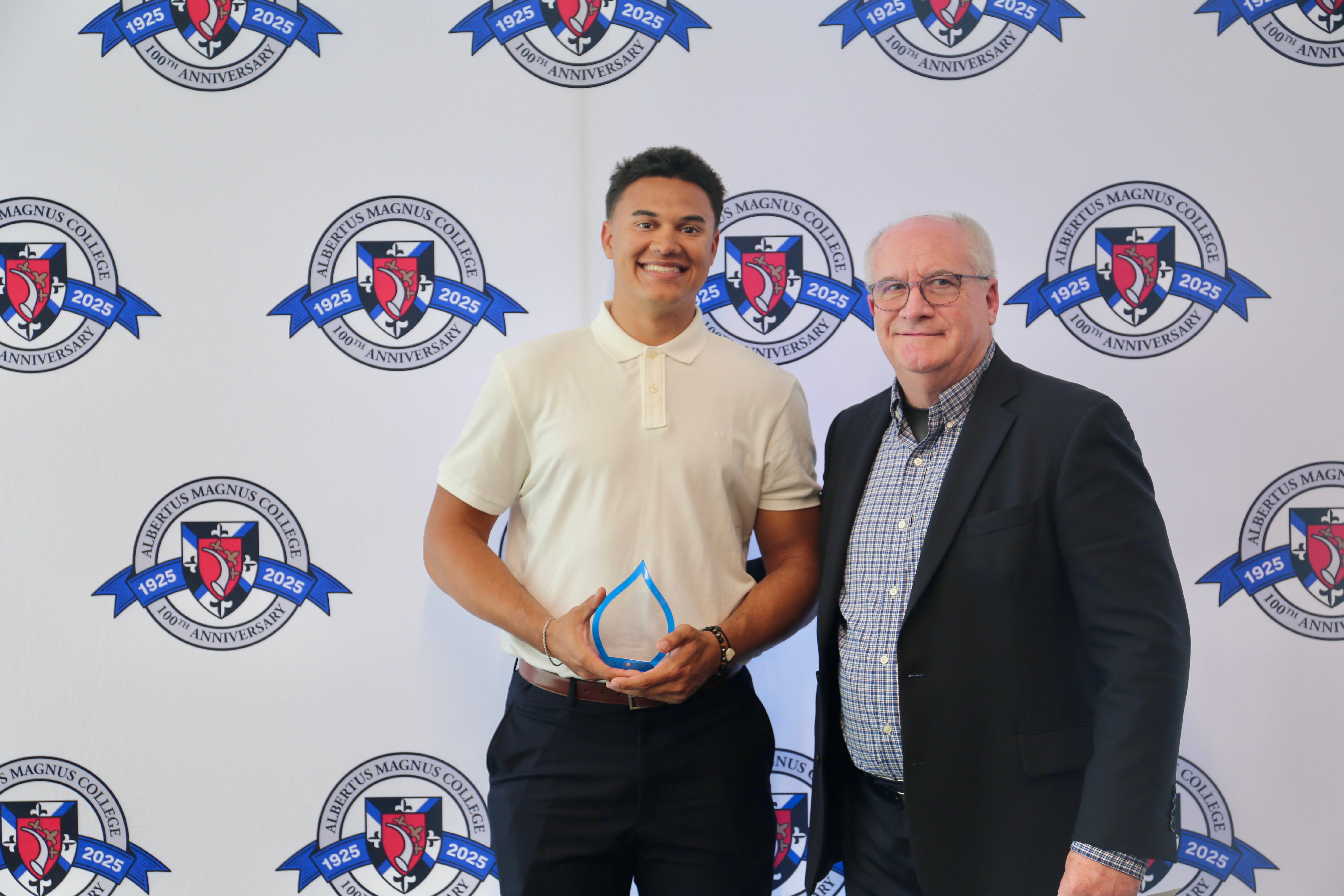 Tate Reilly '27 holding his Falcon Award with Professor Clifford