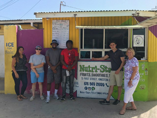 Albertus Magnus College students work together with a small business owner in Kingston, Jamaica