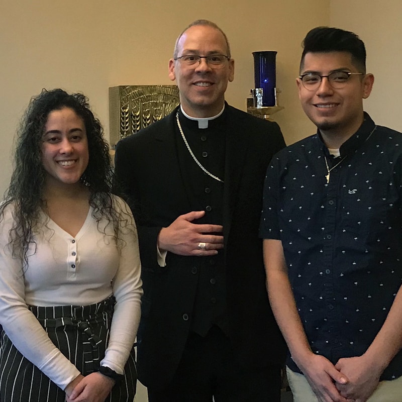 Albertus students Jasmine D. Santiago and Cristian Meneses stand with Bishop Betancourt in the St. Catherine of Siena Chapel
