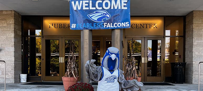Frankie Falcon in front of the campus center